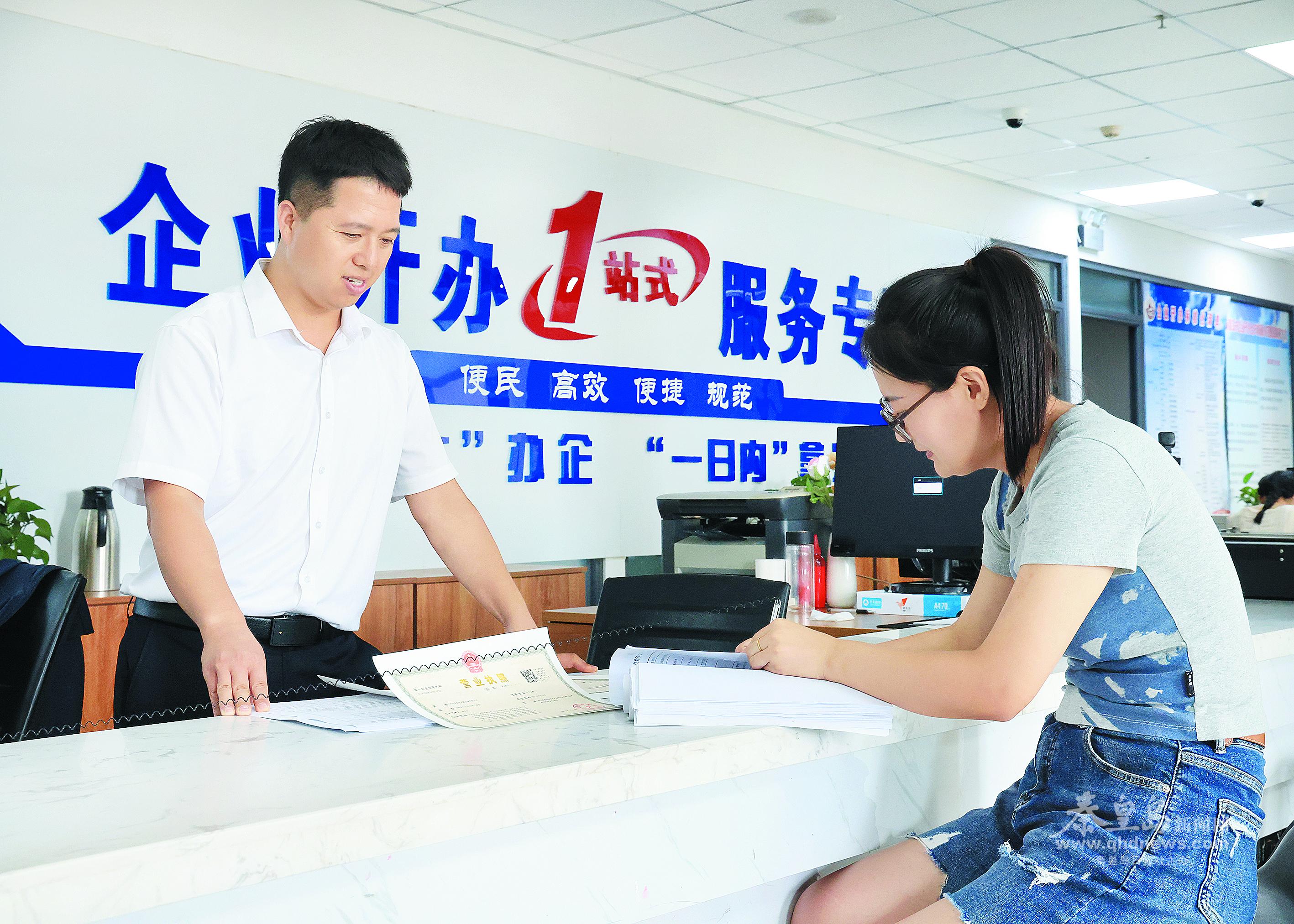 辦事群眾在政務服務大廳工作人員指導下辦理相關手續(xù)。 本報記者李鐸 通訊員 徐鵬遠 攝